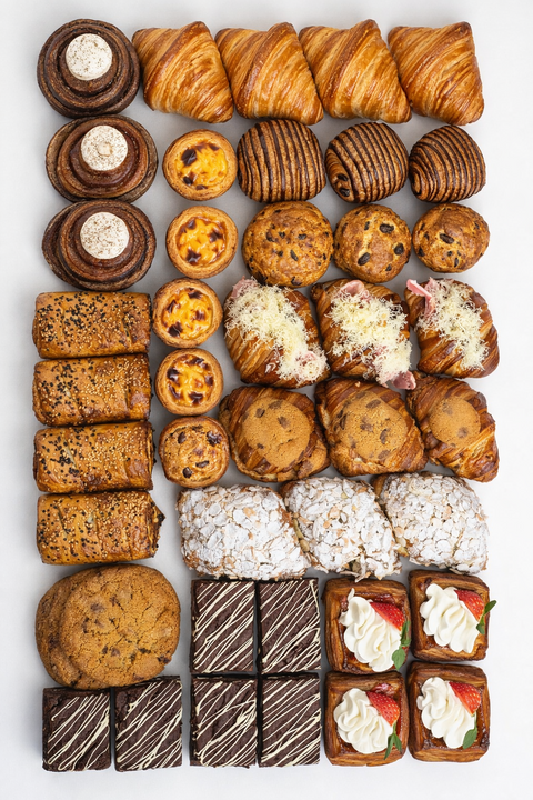Assorted pastries including croissants, cookies, and brownies for wholesale customers