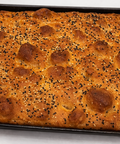 Baked focaccia bread with sesame seeds on a baking tray