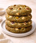 Stack of pistachio cookies on a white plate with a neutral background